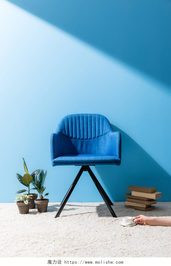 现代风家居沙发椅装饰渲染图舒适的蓝色扶手椅与人拿着杯子咖啡在地板在蓝色墙壁前面